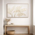 Minimalist hand-painted canvas depicting delicate botanical leaves in soft cream and taupe tones, contemporary entryway