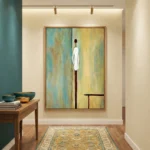 Minimalist figurative hand-painted canvas depicting solitary standing figure in white and deep red tones against layered yellow-green background, contemporary hallway setting