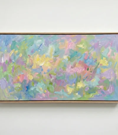 Gestural abstract hand-painted canvas in soft pastels with layered brushstrokes of yellow, pink, blue and green, contemporary living space