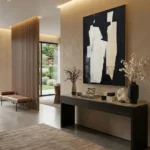 Minimalist abstract hand-painted canvas in monochrome black and cream with gestural white forms, contemporary entryway