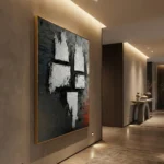 Textured abstract hand-painted canvas with white geometric blocks and red accents on dark background, contemporary hallway