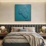 Textured abstract hand-painted canvas depicting flowing feathered form in tonal teal and grey, modern bedroom setting