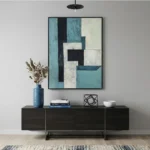 Layered abstract hand-painted canvas in teal, cream, and black geometric forms, modern living space