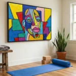 Vibrant expressionist hand-painted canvas depicting a cubist face in bold primary colors and geometric shapes, yoga studio setting