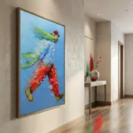 Gestural abstract expressionist hand-painted canvas depicting dynamic figure in vibrant reds, greens and blues, modern hallway setting