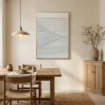 Minimalist abstract hand-painted canvas with intersecting linear brushstrokes in soft grey and white tones, dining space