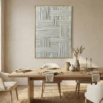 Textured abstract hand-painted canvas with interlocking geometric striations in soft grays and whites, dining space