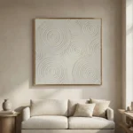 Textured abstract hand-painted canvas with concentric circular patterns in cream and grey tones, contemporary living space