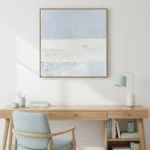 Minimalist landscape hand-painted canvas in soft blue and cream tones with layered horizons, contemporary workspace