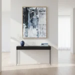 Abstract hand-painted canvas with layered blue and white gestural brushstrokes, contemporary minimalist space