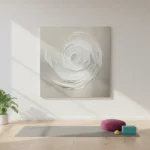 Textured abstract hand-painted canvas depicting a spiraling white rose form in monochromatic tones, yoga studio setting