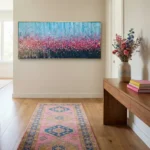 Textured abstract hand-painted canvas depicting layered wildflower field in pink, blue and deep navy tones, contemporary entryway