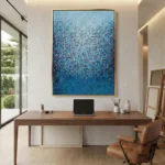 Layered abstract hand-painted canvas in gradient blues and soft whites with textured gestural marks, contemporary home office