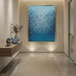 Layered abstract hand-painted canvas in gradient blues and whites with gestural mark-making, contemporary entryway