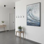 Textured abstract seascape hand-painted canvas in layered blues and whites with gold accents, contemporary entryway