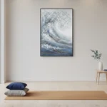 Textured abstract hand-painted canvas depicting a dynamic ocean wave in layered blues and silvery whites, contemporary minimalist space