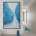 Contemporary landscape hand-painted canvas depicting migrating birds over layered blue forest in cool tones, modern hallway