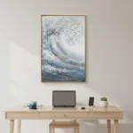 Textured abstract hand-painted canvas depicting swirling ocean waves in layered whites, blues and greys, modern workspace