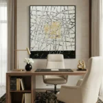 Gestural abstract hand-painted canvas with black expressive line work, gold ochre centre, and dark base, modern office space