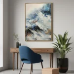 Textured abstract expressionist hand-painted canvas depicting mountainous landscape in layered blues, whites, and earth tones, contemporary workspace