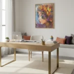 Expressionist hand-painted canvas depicting a woman's profile with vibrant floral headdress in warm gold, purple, and blue tones, contemporary workspace
