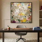 Abstract expressionist hand-painted canvas with layered splattered pigments in ochre, crimson, emerald and cream tones, modern workspace