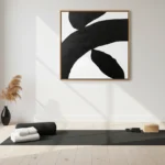 Minimalist hand-painted canvas with bold black and white organic curved forms, yoga studio setting