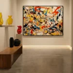 Abstract expressionist hand-painted canvas with dynamic gestural brushstrokes in red, yellow, black, and blue, contemporary gallery space