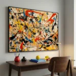 Abstract expressionist hand-painted canvas in bold red, yellow, black and blue gestural strokes, contemporary workspace