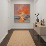 Impressionist seascape hand-painted canvas with dramatic orange sunset reflections and moody blue waters, contemporary entryway