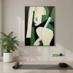 Minimalist hand-painted canvas depicting an abstract female figure in cream and black with bold green accents, yoga studio setting