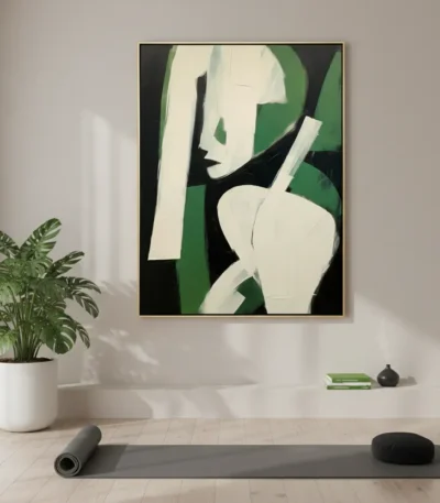 Minimalist hand-painted canvas depicting an abstract female figure in cream and black with bold green accents, yoga studio setting