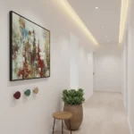 Textured abstract hand-painted canvas with layered red, blue, and ochre gestural brushstrokes, contemporary hallway setting