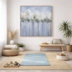 Impressionist hand-painted canvas depicting white flowering trees in misty blue landscape, soft neutral tones, meditation room setting