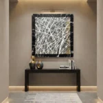 Abstract expressionist hand-painted canvas with gestural white and gold brushstrokes on black, contemporary entryway