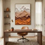 Textured landscape hand-painted canvas depicting layered mountains in cream, terracotta, and ochre tones, contemporary office setting