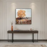 Impressionist landscape hand-painted canvas depicting golden autumn tree over wheat field in warm ochre and blue tones, contemporary entryway