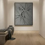 Textured abstract hand-painted canvas with radiating linear brushstrokes in monochrome grey and white, contemporary interior