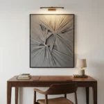 Textured abstract hand-painted canvas in layered cream and grey tones with radiating linear patterns, modern office setting