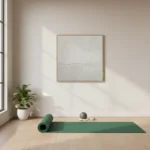 Minimalist abstract hand-painted canvas in soft cream and grey tones with subtle horizontal division, yoga studio setting