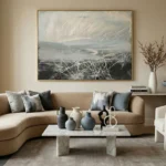 Gestural abstract painting with layered white brushstrokes over muted grey and charcoal tones, hand-painted canvas in contemporary living space