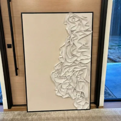 Textured abstract hand-painted canvas with organic sculptural relief forms in cream and ivory tones, contemporary office setting