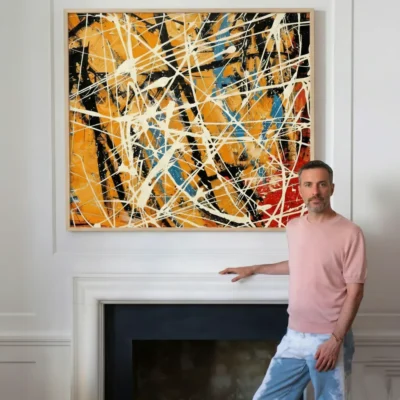 Abstract expressionist hand-painted canvas with energetic white gestural lines, warm ochre and gold tones accented by deep blue and red, modern interior