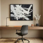 Gestural abstract expressionist hand-painted canvas in dynamic black, white and ochre brushstrokes, modern workspace