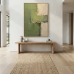 Layered abstract hand-painted canvas in muted green and cream tones with gestural brushwork, contemporary entryway