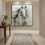 Gestural hand-painted canvas of a white horse with flowing mane in soft grays and earth tones, contemporary entryway