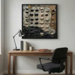 Textured abstract hand-painted canvas with dimensional stone and ceramic elements in charcoal, cream, and terracotta tones, contemporary office setting