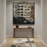 Textured abstract hand-painted canvas with dimensional black and cream oval forms on layered neutral backgrounds, contemporary entryway