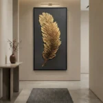 Textured gold leaf hand-painted canvas depicting a single feather in rich metallic tones against deep charcoal, contemporary entryway