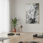 Abstract expressionist hand-painted canvas in monochrome grays and whites with gestural brushstrokes, yoga studio setting